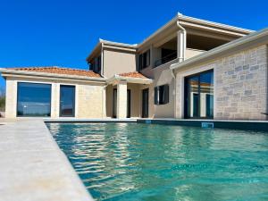 a house with a swimming pool in front of it at Villa Vinova Loza in Kaštelir