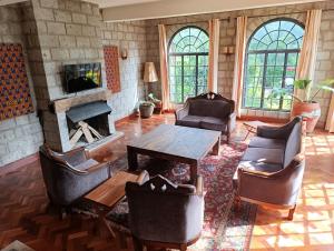 a living room with a fireplace and a table and chairs at Amani House in Nairobi