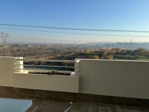 a white balcony with a view of the countryside at Brand New Panoramic Apartment in Vitinia