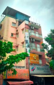 a tall pink building with signs on it at Avenue Inn in Bangalore