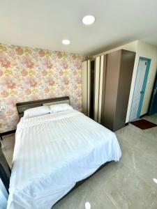 - une chambre avec un grand lit blanc dans l'établissement Arunsakhon luxury condo, à Ban Khok Kham