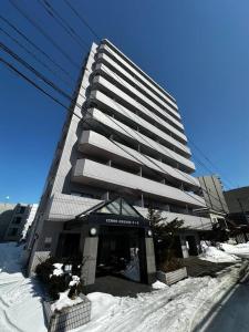 Minami-jūichijōにある9-5 NEW OPEN　美室駅近で眺望良好　駐車場予約可の雪の積もる高層ビル