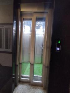 a glass door in a building with a green light at THE MOUNT VALLEY in Haldwāni