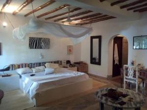 a bedroom with a large white bed in a room at Mwezi Nyota in Malindi