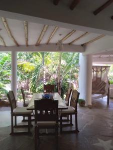 a dining room with a table and chairs and a patio at Mwezi Nyota in Malindi