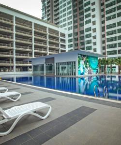 a building with a swimming pool with a billboard on it at D'Chill Suite【Austin Regency】Netflix in Johor Bahru