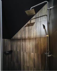 a shower in a bathroom with a wooden wall at Садиба Казка in Vizhenka