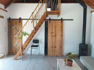 ein Wohnzimmer mit einer Holztreppe und einem Stuhl in der Unterkunft La Barraca de Ro-Casa en el campo con piscina-50 kilimetros de la playa in La Ñora