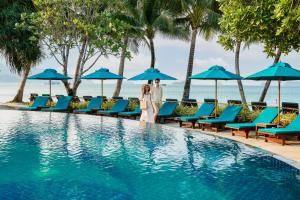 una pareja de pie junto a una piscina en un complejo en Koh Chang Paradise Resort & Spa, en Ko Chang