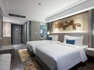 a hotel room with two beds and a room with at Royal Malioboro by ASTON in Yogyakarta