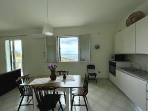 a kitchen and dining room with a table and chairs at Le finestre sul mare in Santa Flavia