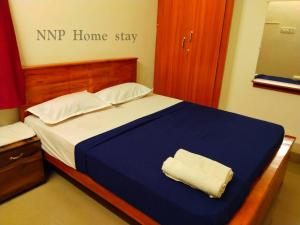a bed in a room with a nip home stay sign at NNP Home Stay Rameswaram in Rāmeswaram