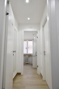 a hallway with white walls and wooden floors at Eletta Guest House in Rome
