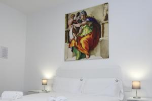 un dipinto appeso sopra un letto in una camera da letto di Eletta Guest House a Roma