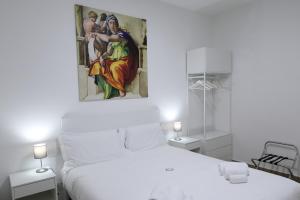 una camera da letto bianca con un dipinto sopra un letto di Eletta Guest House a Roma