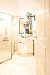 uma casa de banho com um chuveiro, um lavatório e um espelho. em Ha Noi Homestay em Hanói