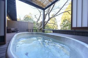 a jacuzzi tub on the deck of a house at Kaze no Tani no Iori in Gamagōri