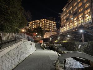 un puente sobre un río en una ciudad por la noche en KAMENOI HOTEL Arima, en Kobe