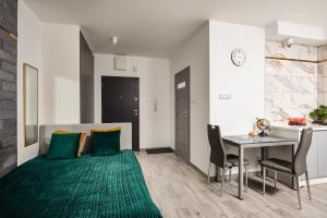 salon ze stołem i zielonym dywanem w obiekcie Lumina apartments with parking, balcony Lodz w Łodzi