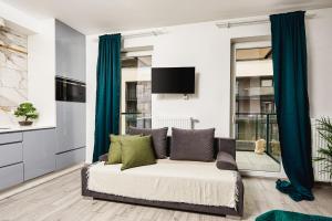 salon z kanapą i telewizorem w obiekcie Lumina apartments with parking, balcony Lodz w Łodzi