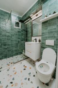 a bathroom with a toilet and a sink and a mirror at CityVibe Residence in Târgu-Mureş