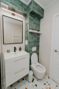a bathroom with a white toilet and a mirror at CityVibe Residence in Târgu-Mureş