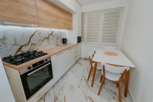 a kitchen with a table and a stove at CityVibe Residence in Târgu-Mureş