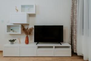 a white entertainment center with a flat screen tv on it at CityVibe Residence in Târgu-Mureş