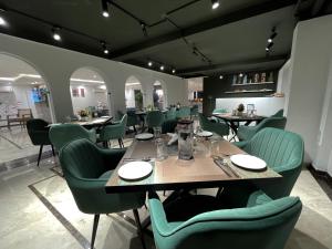 uma sala de jantar com mesas e cadeiras verdes em AVA Hotels and Corporates Millennium City em Gurgaon