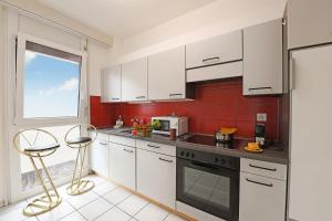 Una cocina con gabinetes blancos y una ventana. en Imbarcadero Apartment - Happy Rentals, en Locarno