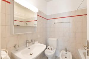 Un baño blanco con lavabo e inodoro. en Imbarcadero Apartment - Happy Rentals, en Locarno