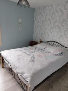 a bedroom with a bed with white sheets and a wall at Maison à la campagne in Saint-Pierre-les-Étieux