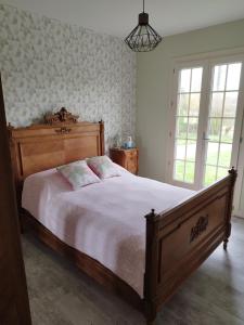 a bedroom with a large bed with a wooden headboard at Maison à la campagne in Saint-Pierre-les-Étieux