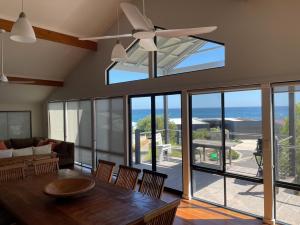 a living room with a table and a ceiling fan at Blue Ocean Haven - Expansive Ocean Views in this Classic Family Beach House in Peppermint Grove Beach in Capel
