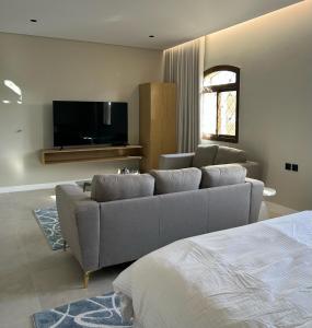 a living room with a couch and a flat screen tv at Maz Apartments in Al Madinah