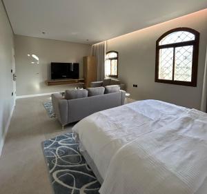 a large bedroom with a bed and a couch at Maz Apartments in Medina