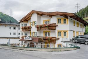 a hotel in the mountains with a car parked in front at Arlen Lodge Appartement in Sankt Anton am Arlberg