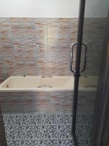 Ban Khouaphan的住宿－DD Guest House，带浴缸的浴室,铺有瓷砖地板
