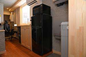a black refrigerator with a microwave on top of it at JR Mobile Inn Chitose in Chitose
