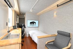 a small room with a bed and a sink at JR Mobile Inn Chitose in Chitose