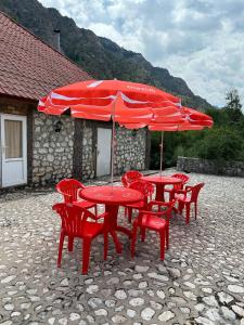 een groep rode tafels en stoelen met rode parasols bij Motel Oson in Chichkan Gorge, Toktogul, Kyrgyzstan, Мотель Осон в ущелье Чычкан, Токтогул, Кыргызстан in Dzhenish