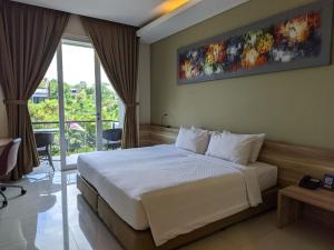 a bedroom with a large bed and a large window at Mahogany Hotel in Nusa Dua