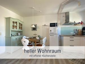 a kitchen with a table and a refrigerator at Fewo Herzgrün mit Balkon und Traumblick direkt an Wanderwegen und Sauna im Haus in Todtnauberg