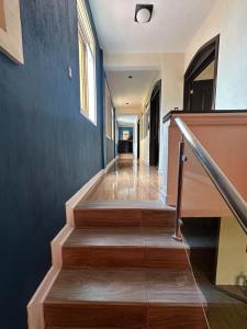 un couloir avec des escaliers et un mur bleu dans l'établissement CASA DE DESCANSO TZANJAAY, à San Juan La Laguna