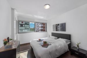 biała sypialnia z łóżkiem i oknem w obiekcie Art Apartment - Happy Rentals w mieście Locarno