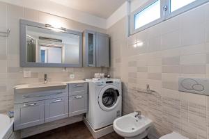 W łazience znajduje się pralka i umywalka. w obiekcie Art Apartment - Happy Rentals w mieście Locarno