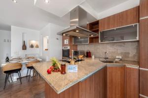 Una cocina con gabinetes de madera y encimera. en Art Apartment - Happy Rentals, en Locarno