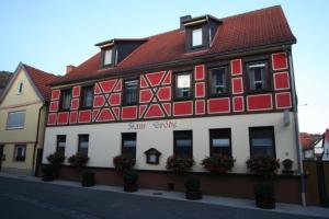 un edificio rojo y blanco con flores delante en Wohnung in Ilfeld mit Grill und Garten, en Harztor