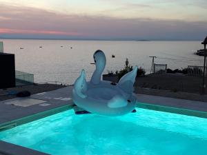 un cygne gonflable assis au-dessus d'une piscine dans l'établissement Villa Sea Queen, à Novalja