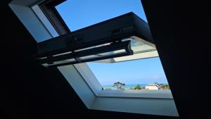 a window in a room with a view of the ocean at Studio cosy au bord de mer in Lancieux